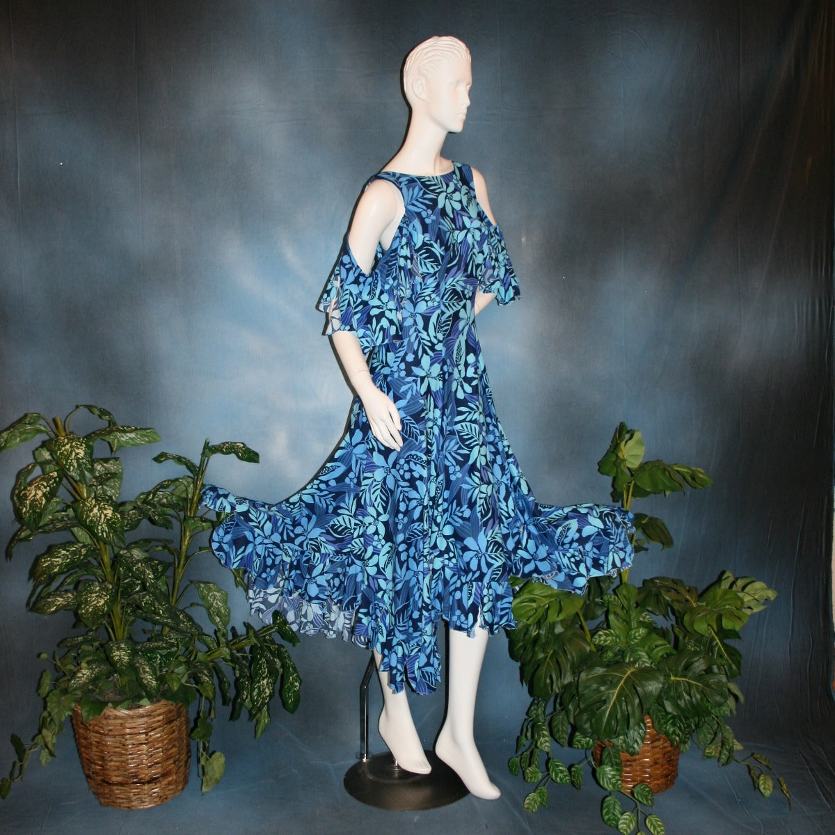 side view of Blue social ballroom dress created in tropical blue print lycra with oodles of flounces, draping cold shoulder sleeves with flounces.