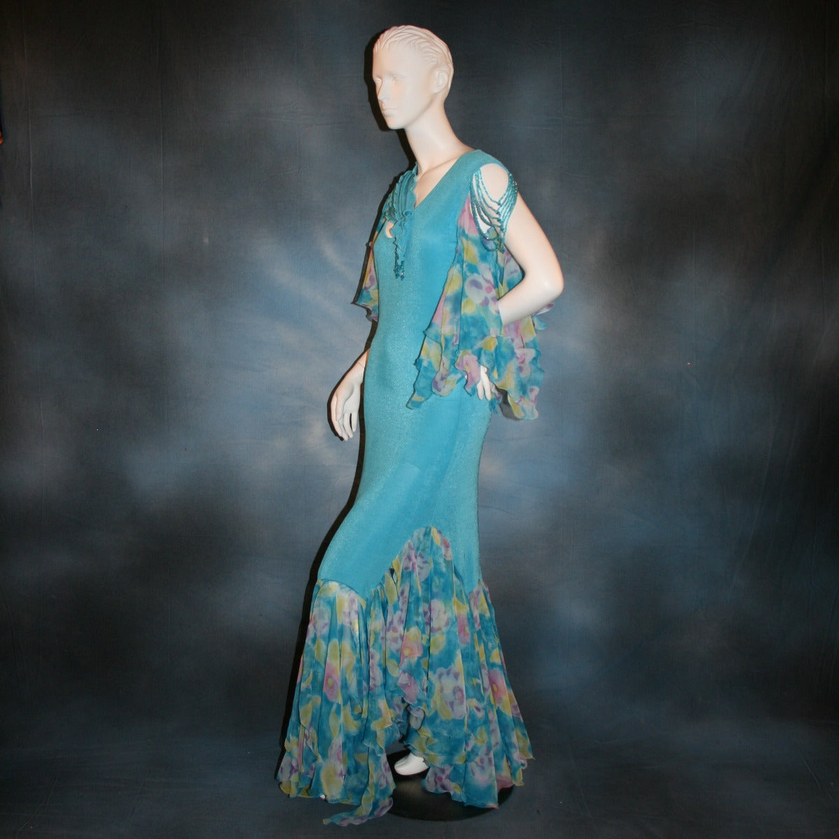 side view of Blue social ballroom dress of luxurious robin egg blue slinky, print chiffon flounces & floats with touches of orchid & yellow, embellished with Swarovski hand beading, is lovely for any ballroom dance or special occasion, and a fabulous beginner ballroom dancer show dress!