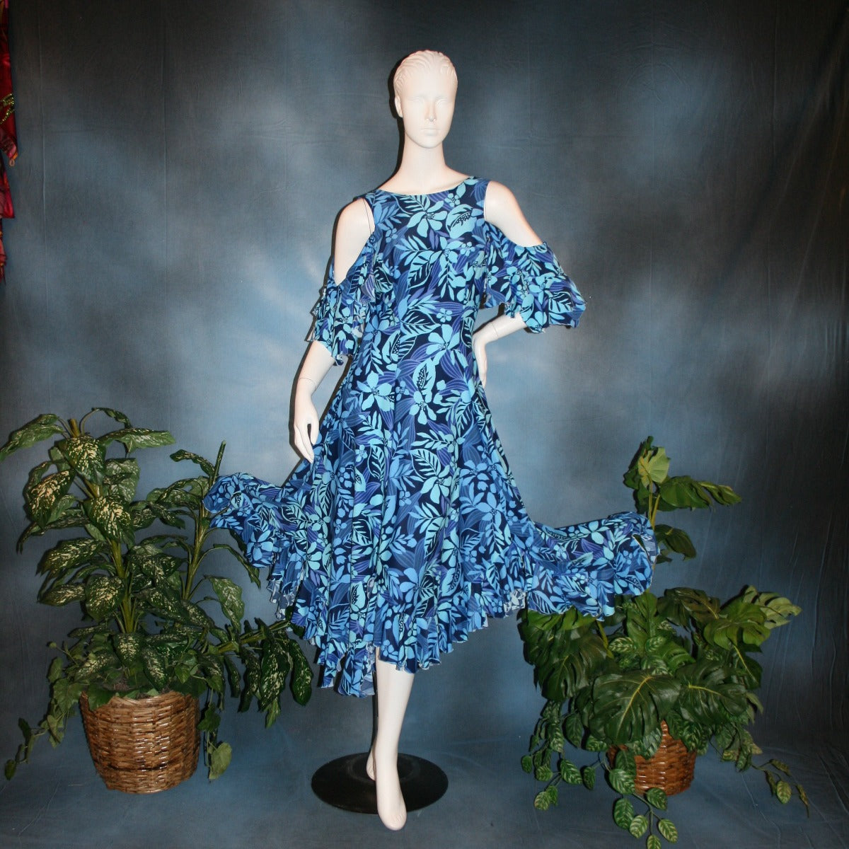 Blue social ballroom dress created in tropical blue print lycra with oodles of flounces, draping cold shoulder sleeves with flounces.