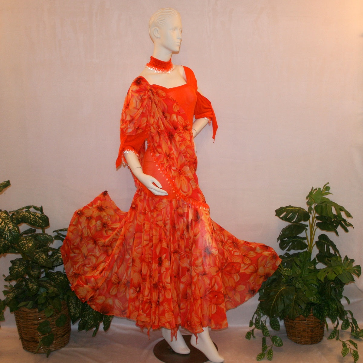 side view of Orange ballroom dress with 3/4 cold shoulder, billowy sleeves, created of luxurious orange solid slinky & yards of an orange tropical print textured chiffon. 