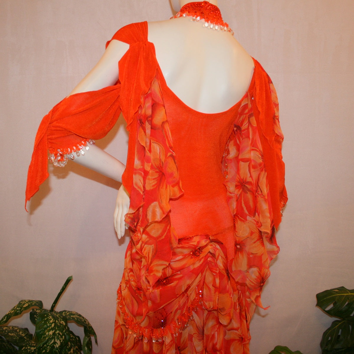 upper back view of Orange ballroom dress with 3/4 cold shoulder, billowy sleeves, created of luxurious orange solid slinky & yards of an orange tropical print textured chiffon. 