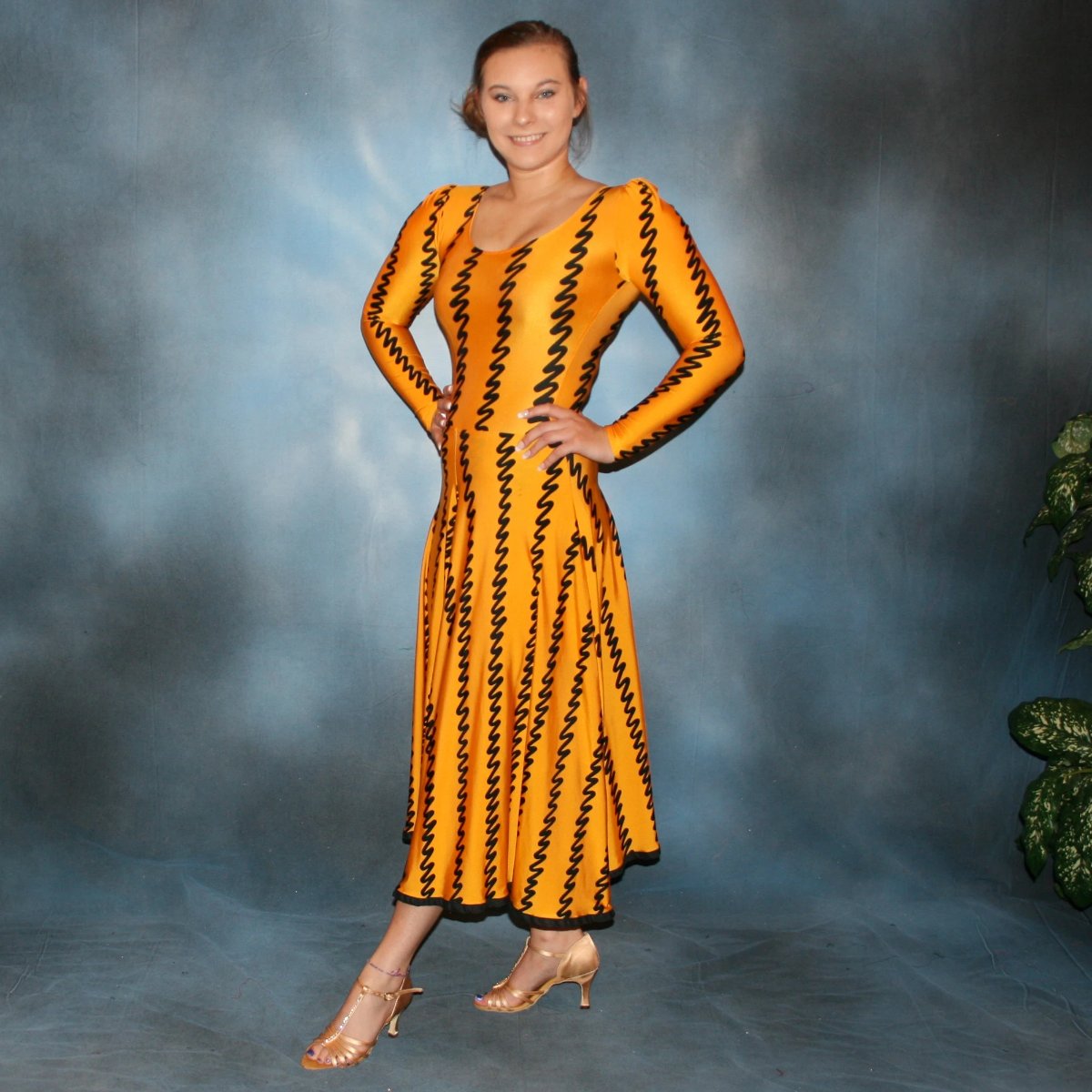 side view of Deep yellow long sleeved bodysuit & flaired ballroom skirt created in deep yellow print lycra with black zig zag vertical print, black binding on skirt edge. Great for any ballroom dance, practice, ballroom teachers or social event!