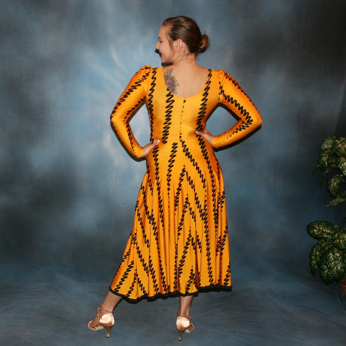 back view of Deep yellow long sleeved bodysuit & flaired ballroom skirt created in deep yellow print lycra with black zig zag vertical print, black binding on skirt edge. Great for any ballroom dance, practice, ballroom teachers or social event!