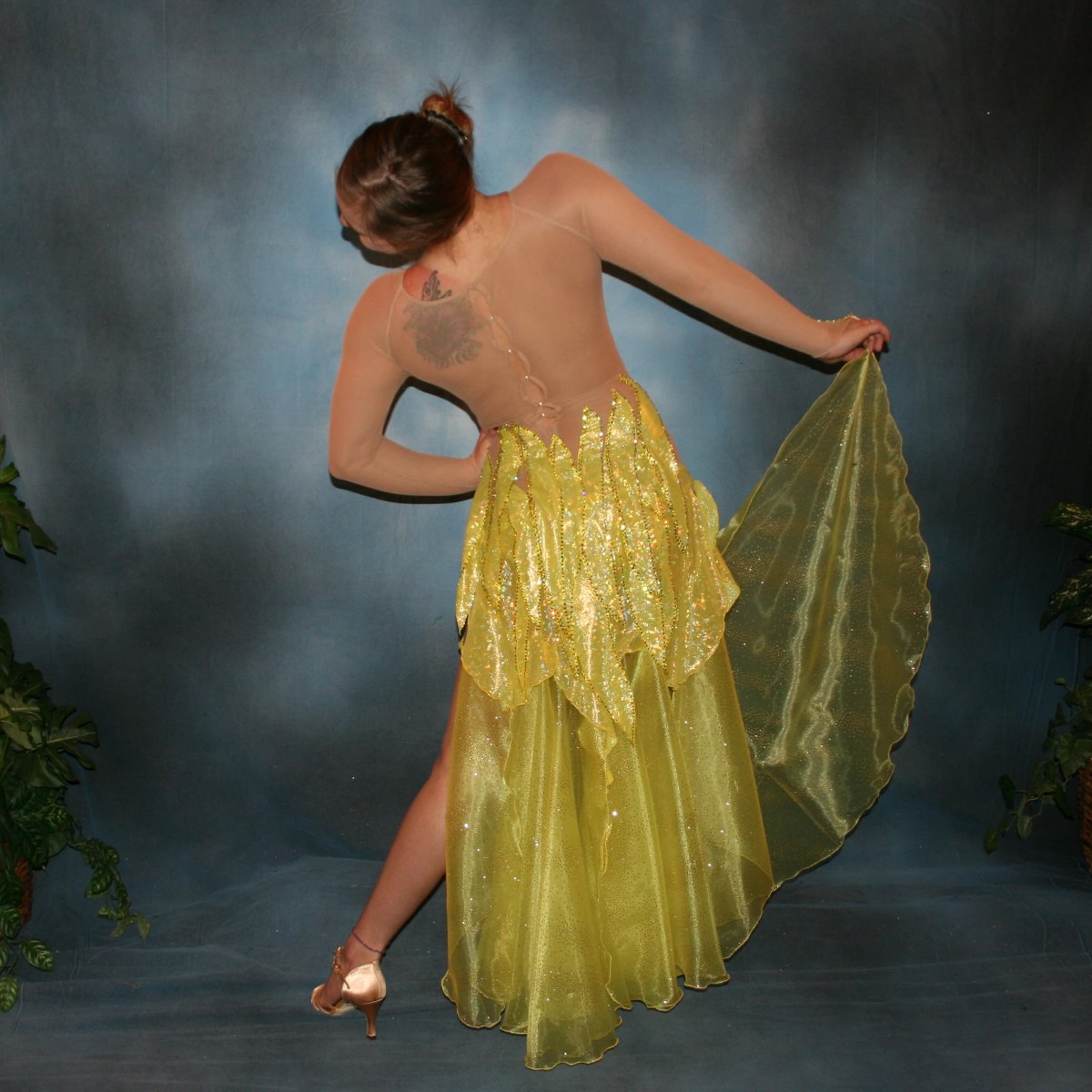 Crystal's Creations back view of Yellow converta ballroom dress consisting of Latin/rhythm dress created of yellow hologram lycra, with handcut petal appliques overlaid artistically on nude illusion base,embellished with citrine & jonquil ab Swarovski rhinestones, with converta skirt of yards of glittered organza.