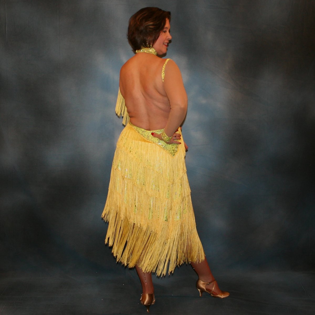 Crystal's Creations back view of Yellow Latin/rhythm fringe dress created in yellow splash metallic lycra with yards of chainette fringe, sheer nude illusion sleeves, embellished with jonquil Swarovski rhinestones.
