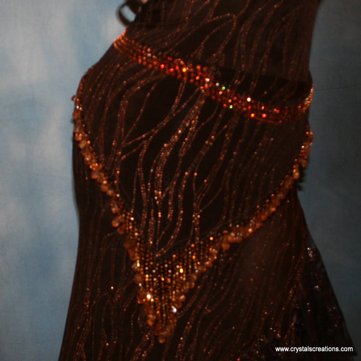 Crystal's Creations close up view of Brown tango dress, bolero dress or rumba dress created in chocolate brown &amp; bronze glitter slinky with chocolate brown metallic lace &amp; metallic tricot flounces is embellished with crystal copper Swarovski rhinestones at neckpiece & hipsash, which also has extensive hand beading.