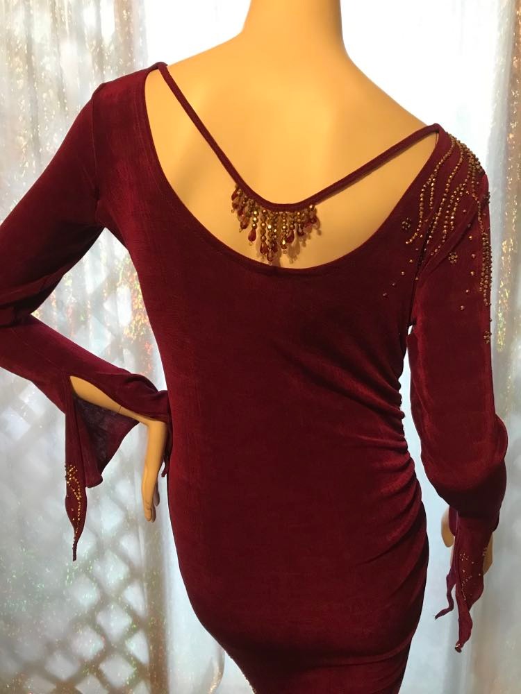 Crystal's Creations upper back view of Magenta Latin/rhythm/tango dress created out of deep magenta/wine slinky features ruching, long flared sleeves & is embellished with gold aurum Swarovski rhinestone work with a bit of Swarovski bead detail on back strap