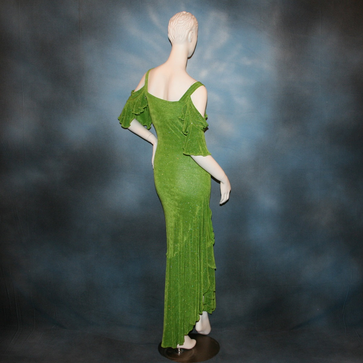 side back view of Apple green social Latin/rhythm/tango dress created of apple green glitter slinky with full flared bottom skirting & cold shoulder petal flounce sleeves.