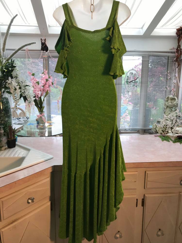 back view of Apple green social Latin/rhythm/tango dress created of apple green glitter slinky with full flaired bottom skirting & cold shoulder petal flounce sleeves.