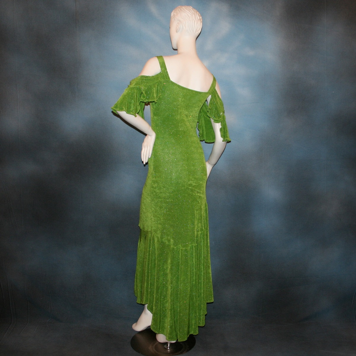back view of Apple green social Latin/rhythm/tango dress created of apple green glitter slinky with full flared bottom skirting & cold shoulder petal flounce sleeves.