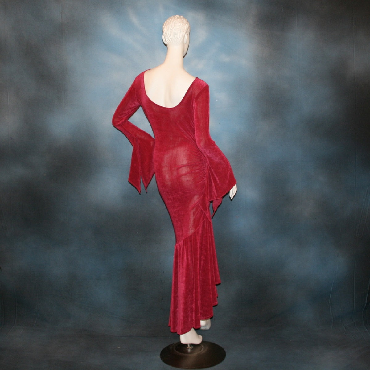 back view of Deep rose Latin/rhythm/social dress created of luxurious deep rose slinky features ruching up the right side & long sleeves with an open flared detail.