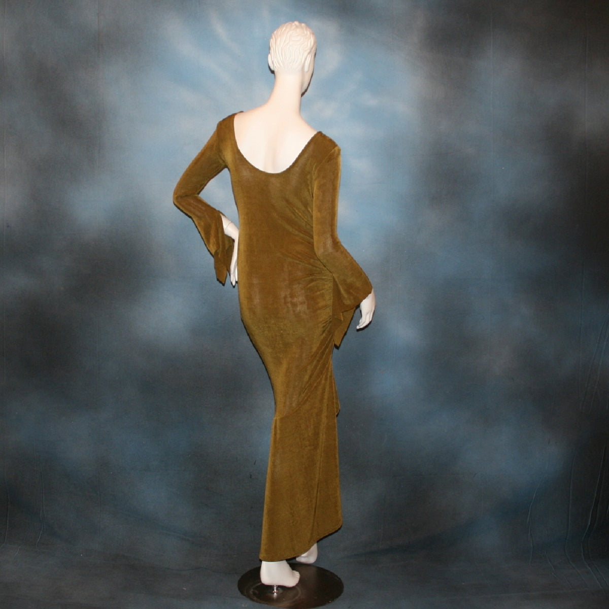back view of Sage green Latin/rhythm/social dress created of luxurious sage green slinky features ruching up the right side & long sleeves with an open flared detail.