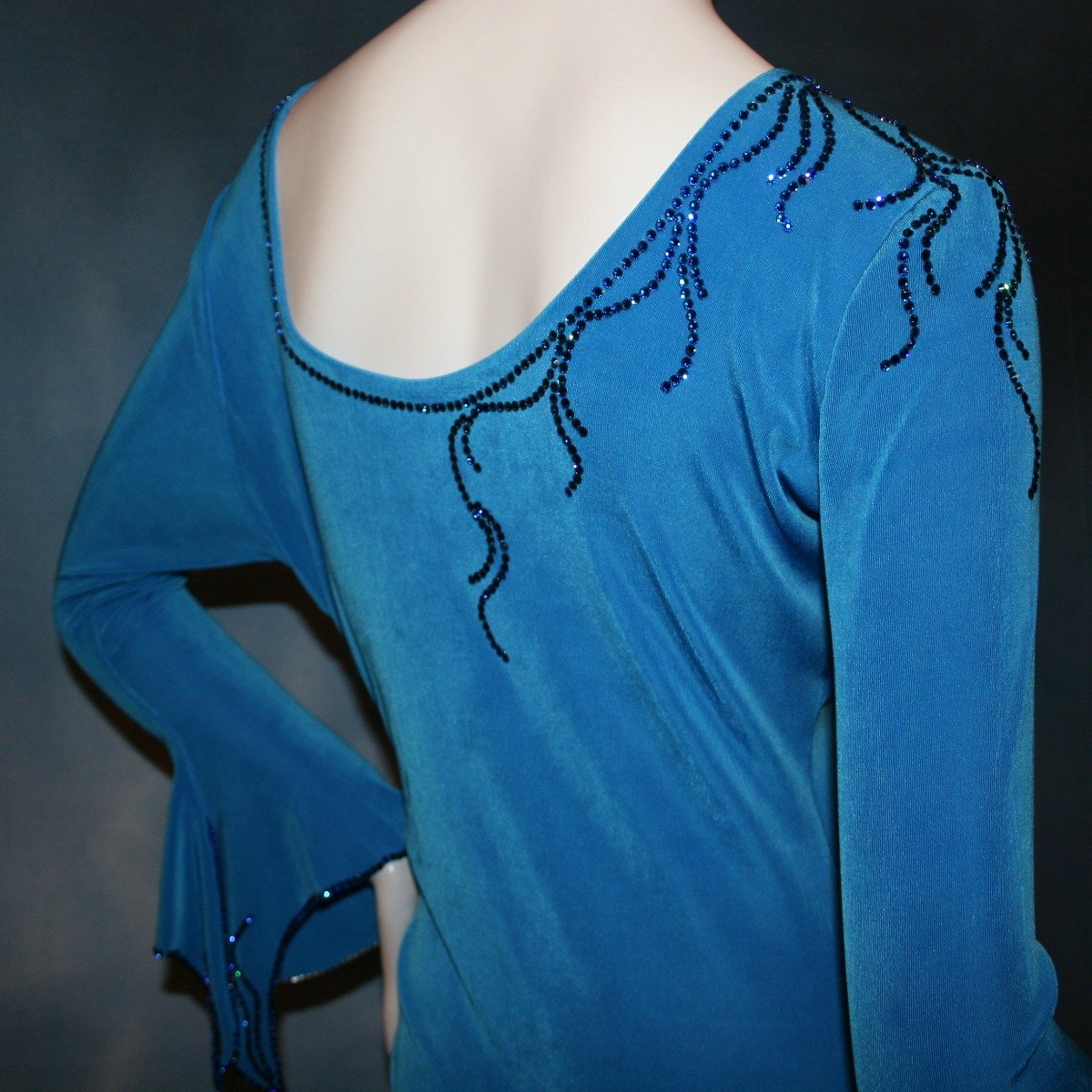 Crystal's Creations close up view of blue Latin/rhythm dress created of luxurious blue slinky, embellished with Swarovski detailed rhinestone work