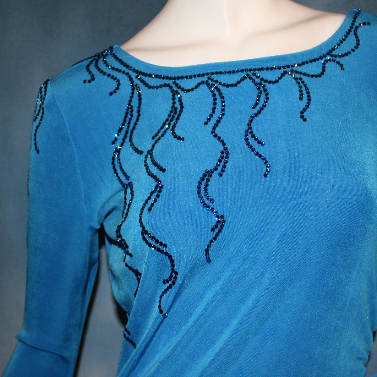 Crystal's Creations close up view of  blue Latin/rhythm dress created of luxurious blue slinky, embellished with Swarovski detailed rhinestone work