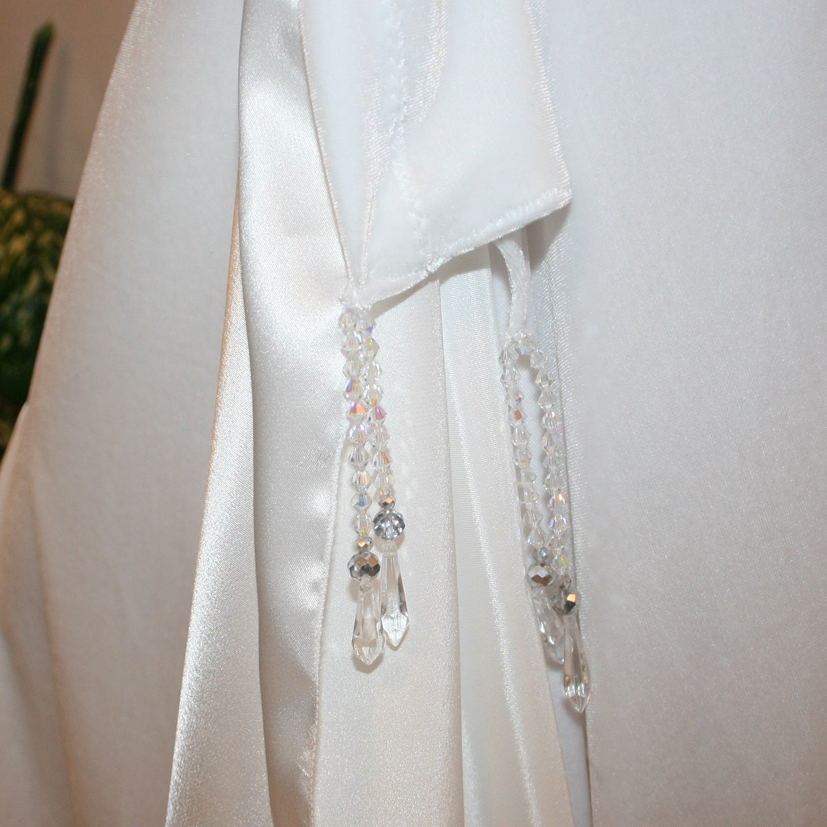 close detail view of bead work on White ballroom skirt is very full & created of luxurious white stretch velvet with white charmeuse insets & floats has a hip sash with Swarovski hand beaded accents. 