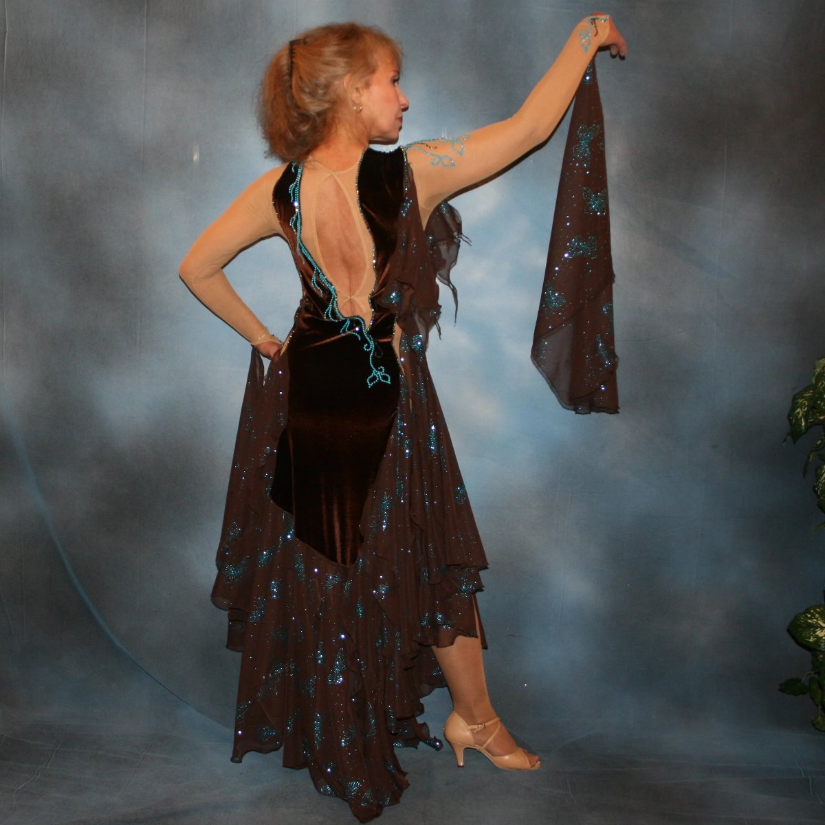 Crystal's Creations back view of Exquisite brown ballroom dance dress with turquoise accents was created in luxurious chocolate brown stretch velvet on a nude illusion base…featuring billowing yards of brown chiffon petal panels with glittery turquoise butterflies. 