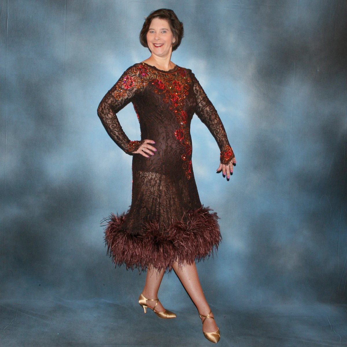Crystal's Creations side view of Chocolate brown Latin/rhythm dance dress of stretch lace lavished with detailed Swarovski stonework done in Indian pink* & crystal copper… with ostrich feathers adorning the skirt edge…and includes under bodysuit.
