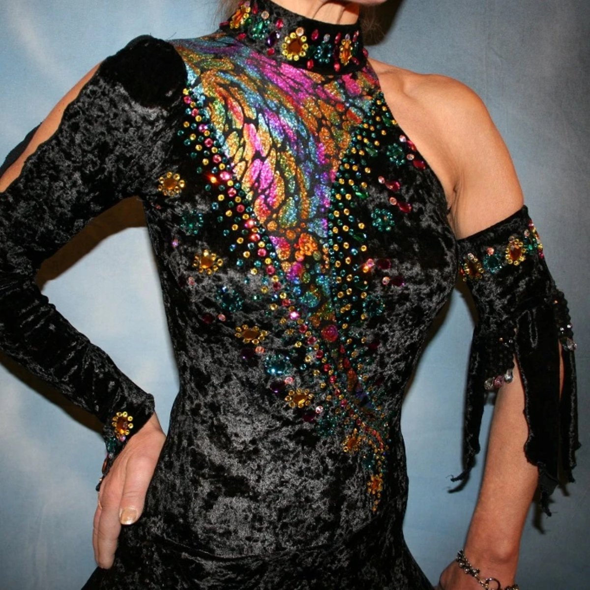 close upper view of Black Latin/rhythm dress created in black panne velvet with colorful confetti hologram lycra accents, is embellished with hand beading, Swarovski CAB, citrine, & blue zircon rhinestones plus large colorful acrylic gems.