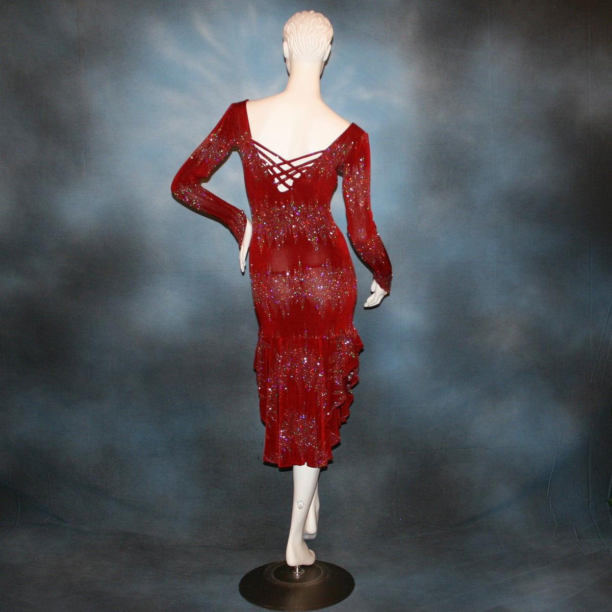 backview of Deep scarlette red Latin/rhythm/tango dress created in glitter slinky with an awesome electrifying glitter pattern features lattice detailing in the back, long sleeves with Swarovski hand beading in the skirt sides.