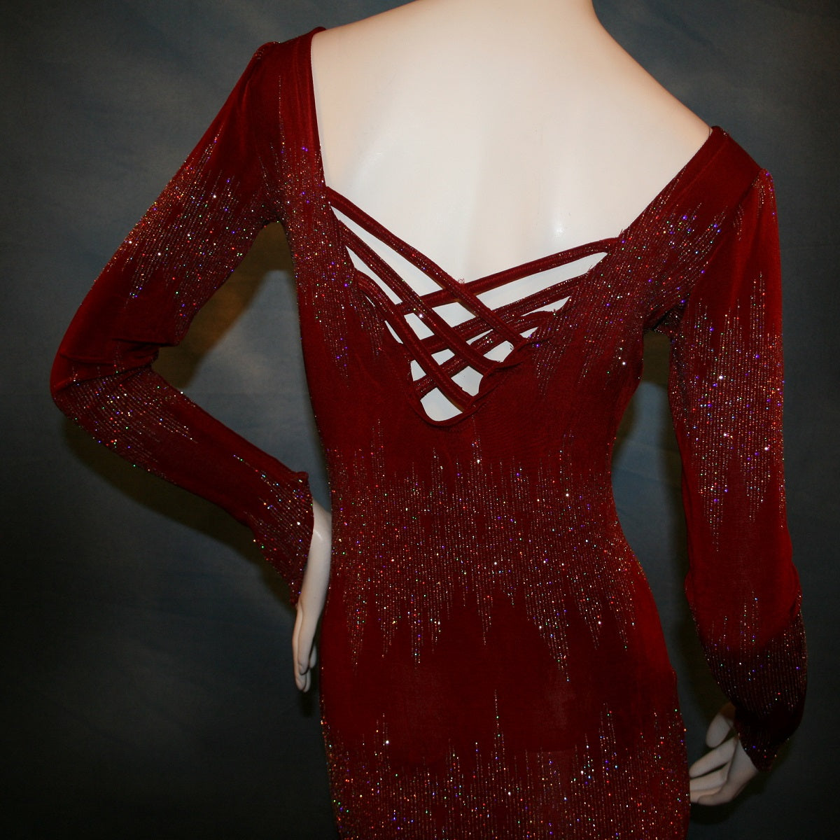 close back view of Deep scarlette red Latin/rhythm/tango dress created in glitter slinky with an awesome electrifying glitter pattern features lattice detailing in the back, long sleeves with Swarovski hand beading in the skirt sides.