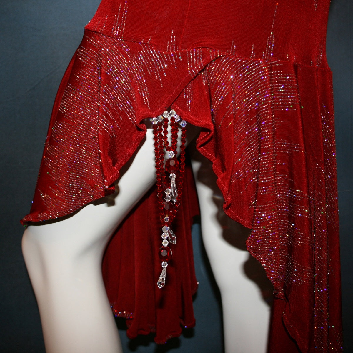close up details of Deep scarlette red Latin/rhythm/tango dress created in glitter slinky with an awesome electrifying glitter pattern features lattice detailing in the back, long sleeves with Swarovski hand beading in the skirt sides.