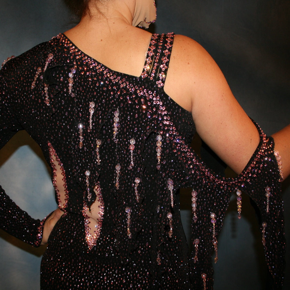 Crystal's Creations close back view of black Latin/rhythm dress created of black glitter slinky with light pink glitter accents that look like champagne bubbles, is embellished with light rose pink Swarovski rhinestone work & hand beading