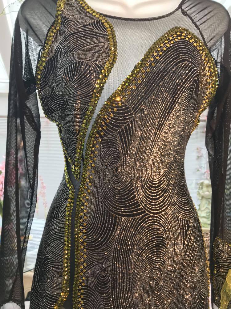 Crystal's Creations close front view of silver Latin/rhythm dress created of silver swirls glitter slinky fabric artisically cut & laid over sheer black stretch mesh features lime green scarf shape flounces & Olivine Swarovski rhinestone work. size 5/6-9/10