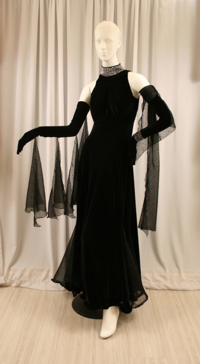 Black ballroom dress created of luxurious black stretch velvet with champagne sequined chiffon insets & floats, embellished with CAB Swarovski rhinestone work on the neck, wrist band & back straps. 
