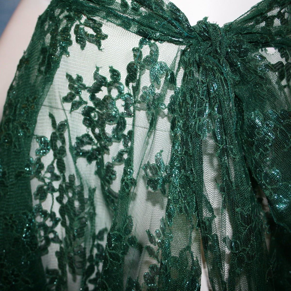 close view of Very full emerald green lace ballroom skirt, wrap style, was created with yards of deep emerald green metallic lace.