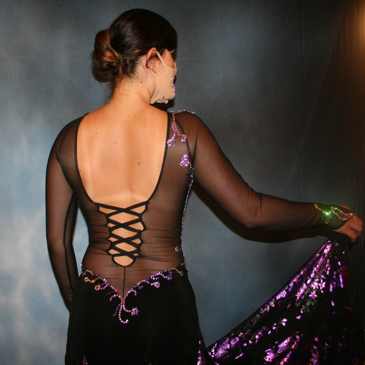 Crystal's Creations close up back view of Black ballroom dance dress with purple accentswas created in luxurious black solid slinky on stretch mesh base figure contouring bodysuit, featuring yards of black & purple metallic print chiffon, enhanced with intricately detailed tanzinite & vitrail light Swarovski rhinestone work.