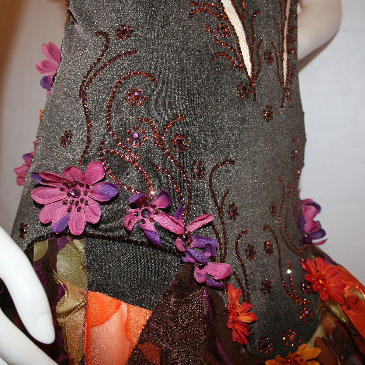 mid view details of Brown converta ballroom dress created in deep chocolate brown slinky on a nude illusion base with panels of a gorgeous flowered chiffon with a sheen in browns, oranges, yellows, greens, burgundies & purples, with silk flower embellishments & Swarovski detailed rhinestone work.