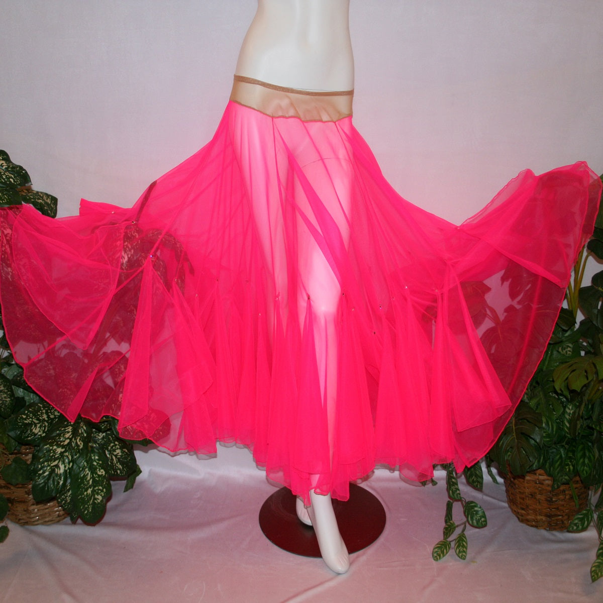 flaired view of Hot pink ballroom skirt created with yards of hot pink sheer tricot with petal like floats around bottom embellished with tear drop Swarovski rhinestones.