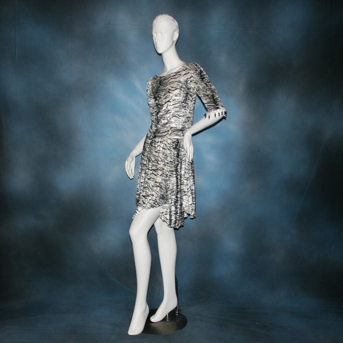 side view of Top & tulip style Latin/rhythm dance skirt created in white tiger print panne’ velvet with hand beading on sleeve edges of top. This is a fun & flirty Latin/rhythm dance set great for juniors as well!