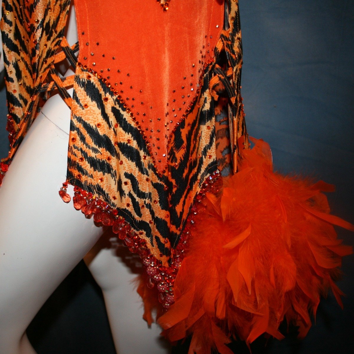 Crystal's Creations close up bottom view of orange & black tiger print Latin/rhythm dress with orange chandelle feathers & hand beading