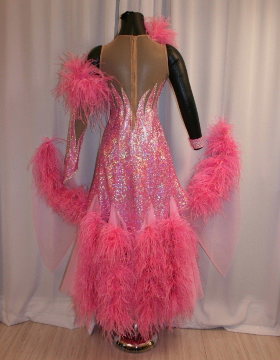 Crystal's Creations back view of Pink ballroom dress created of pink hologram lycra on nude illusion base, chiffon paneled skirting with ostrich feathers, embellished with CAB Swarovski rhinestone work. It also includes the arm embellishments.