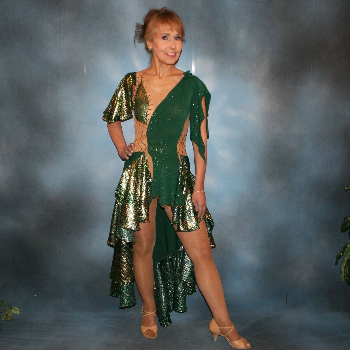 Crystal's Creations Green Latin/rhythm dress was created on a nude illusion base of deep emerald green glitter slinky fabric along with flounces & accents of rich emerald green & gold tropical print sequin fabric, embellished with gold aurum Swarovski stonework plus hand beaded detailing.