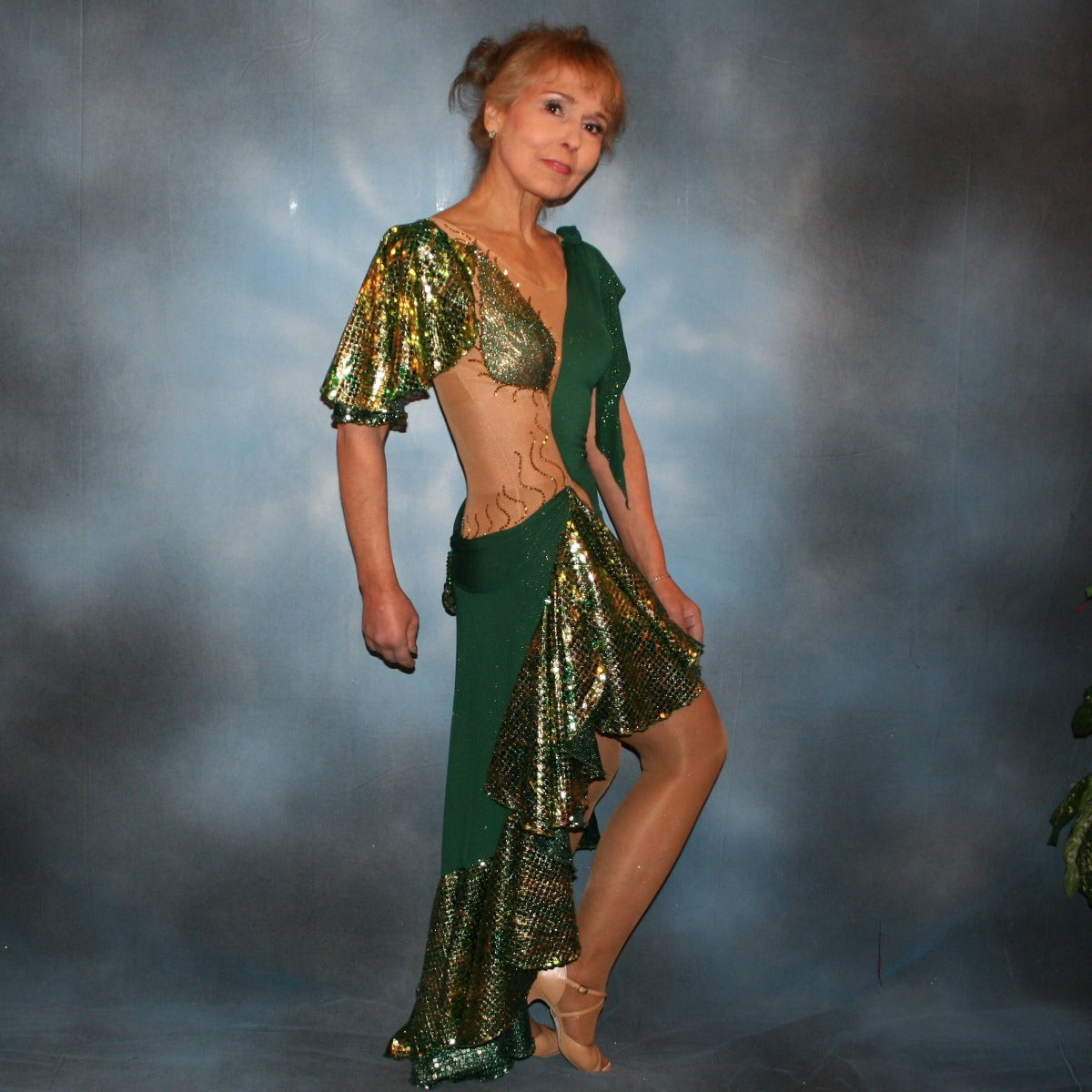 Crystal's Creations side view of Green Latin/rhythm dress was created on a nude illusion base of deep emerald green glitter slinky fabric along with flounces & accents of rich emerald green & gold tropical print sequin fabric, embellished with gold aurum Swarovski stonework plus hand beaded detailing.