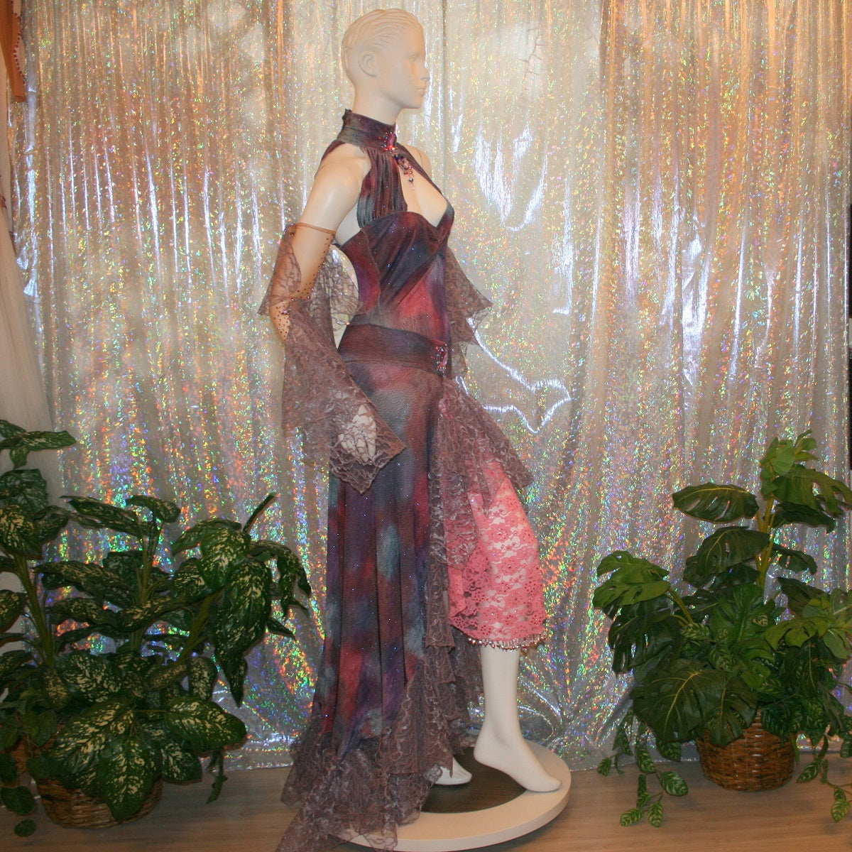 side view of Orchid & pink rumba-bolero dress, also fabulous for a ballroom solo dance, created in tye dye glitter slinky of orchids & pinks is actually a bodysuit & skirt with oodles of orchid Barcelona lace flounces, embellished with Swarovski rhinestone work & hand beading, incudes nude illusion gauntlets with Swarovski rhinestone work & flounces spiraling down each arm.