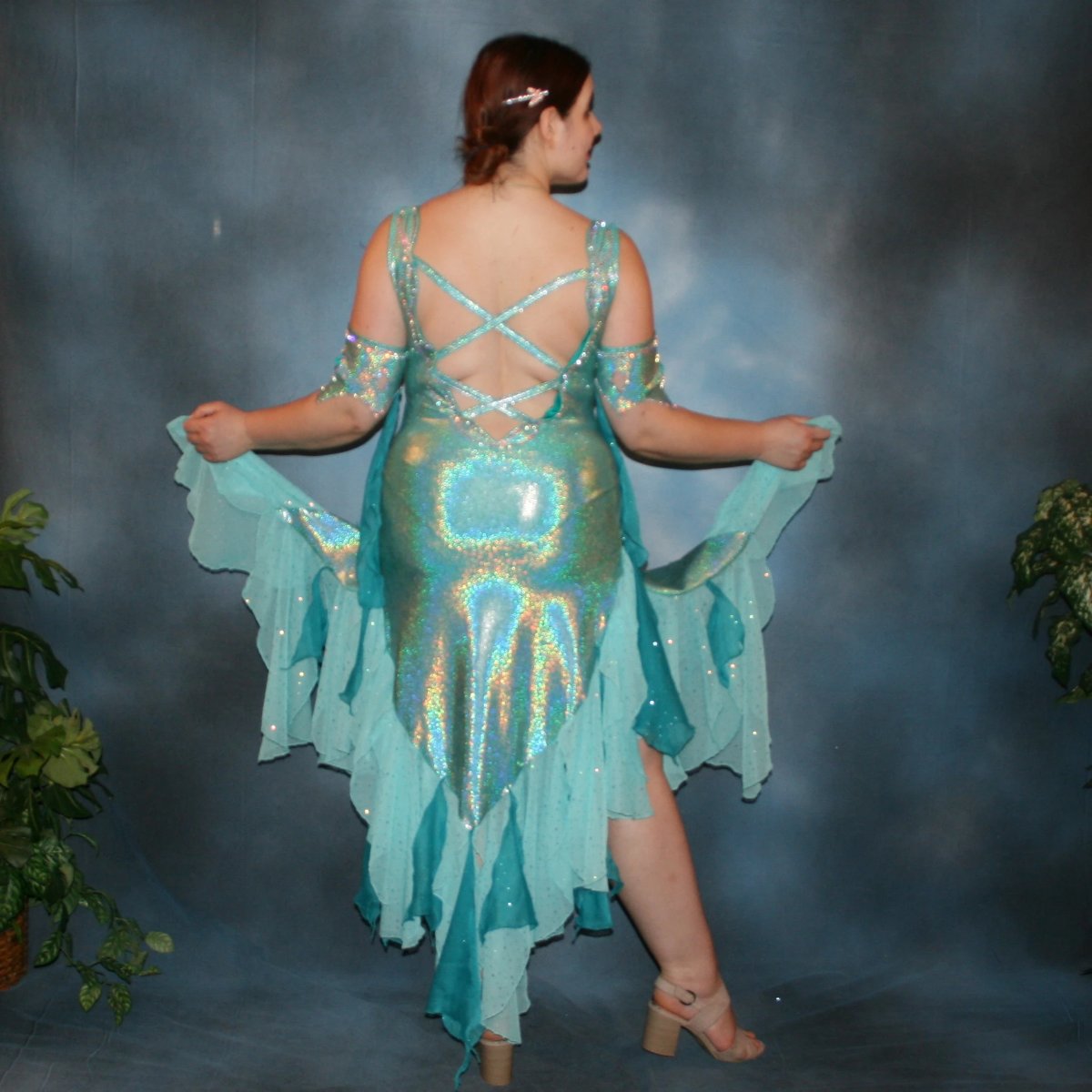 Crystal's Creations back view of Aqua Latin/rhythm dress created of gorgeous hologram base with flounces of aqua champagne sequin chiffon & teal glitter chiffon, embellished with CAB Swarovski stone work, with strap detailing on back. I envision this magical dress a gorgeous rumba, bolero or even a great solo dress for a waltz or foxtrot….or for an all around division.