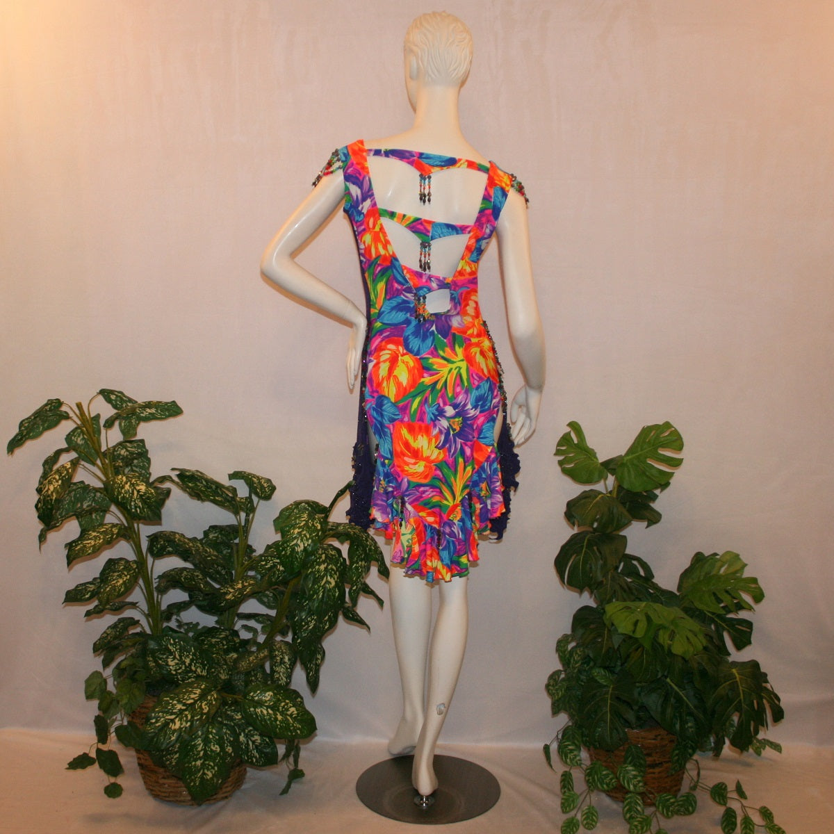 back view of Tropical print Latin-rhythm dress created in tropical print lycra with side color blocking in deep purple glitter slinky with lots or flounces, back detailing, embellishing with Swarovski hand beading.