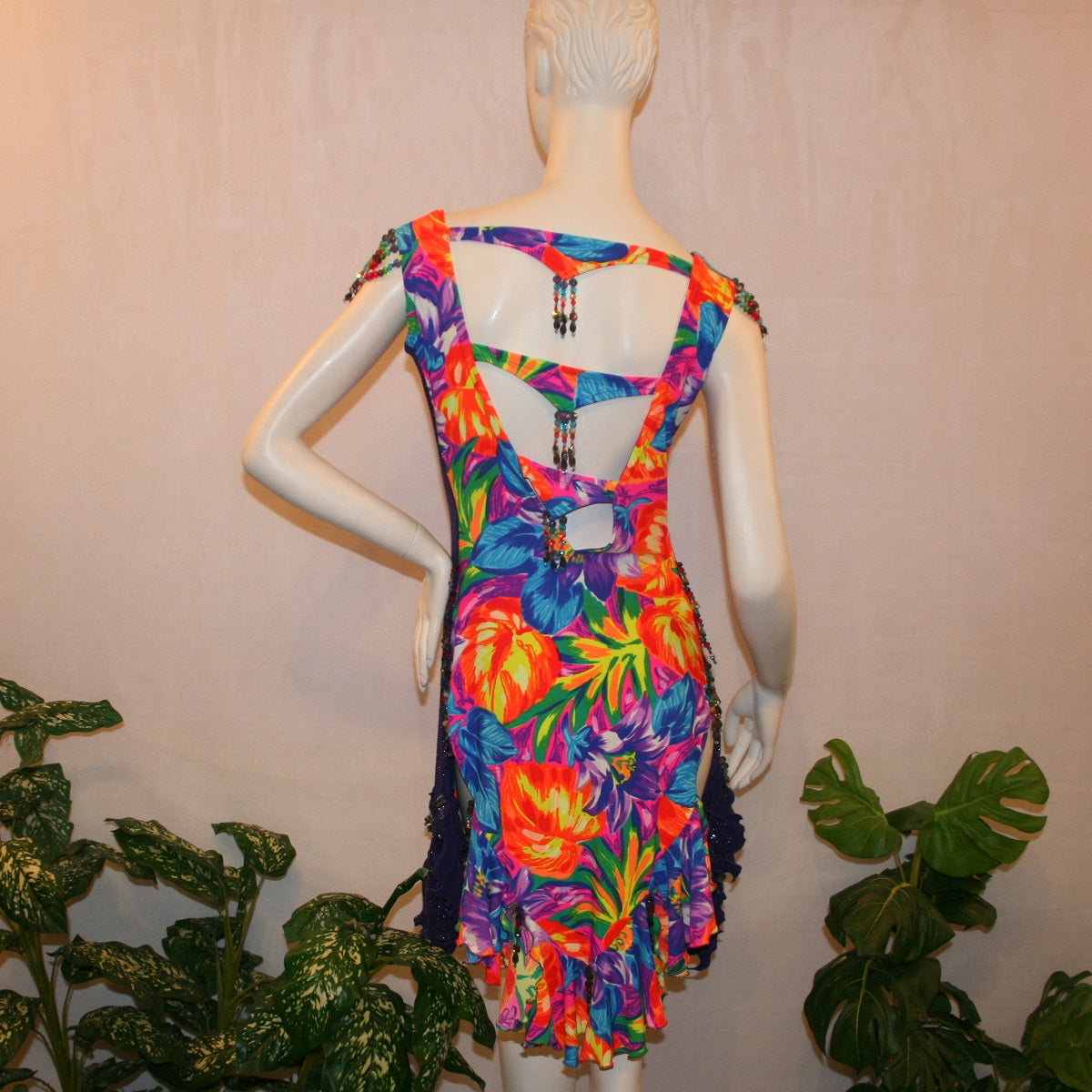 back view of Tropical print Latin-rhythm dress created in tropical print lycra with side color blocking in deep purple glitter slinky with lots or flounces, back detailing, embellishing with Swarovski hand beading.