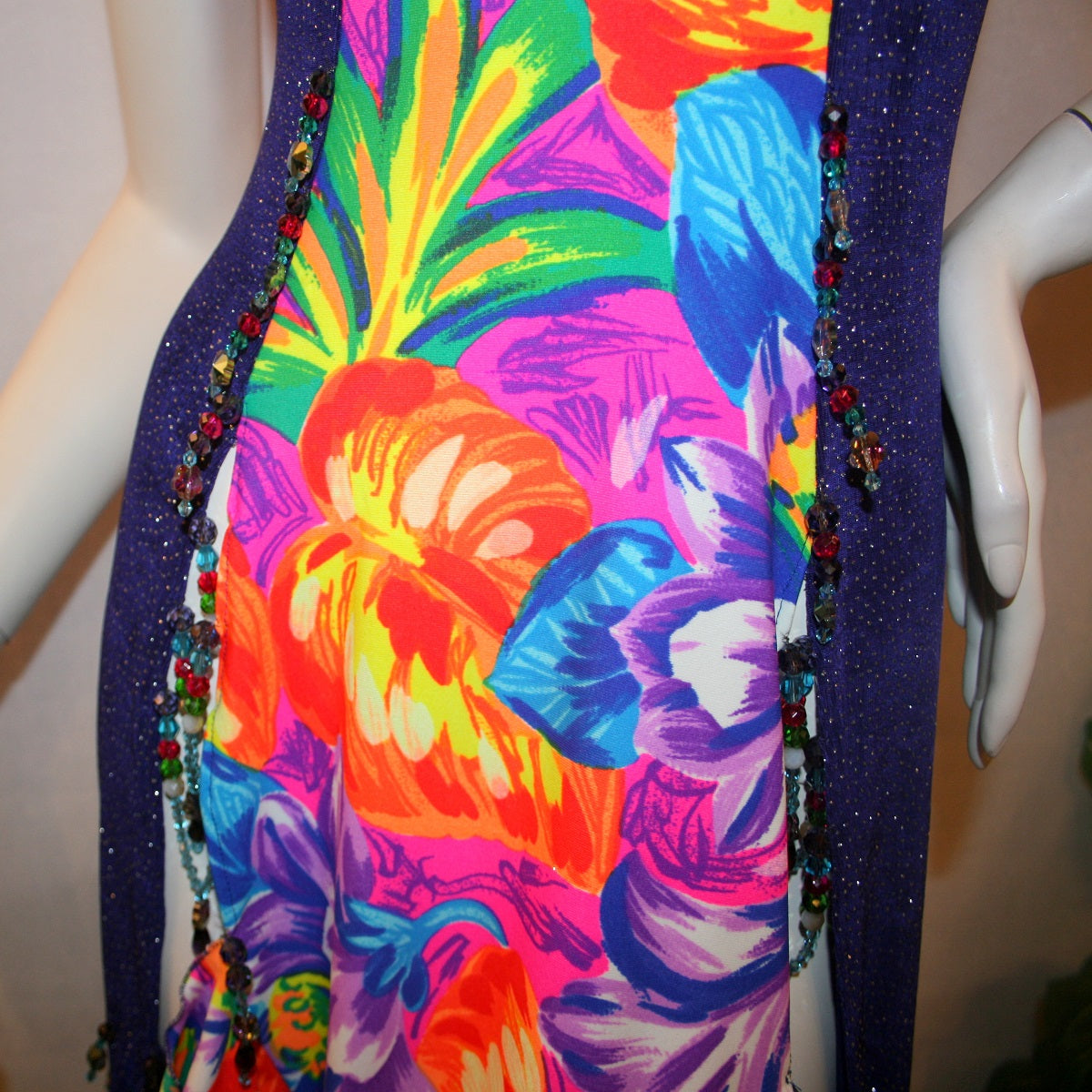 beading details on Tropical print Latin-rhythm dress created in tropical print lycra with side color blocking in deep purple glitter slinky with lots or flounces, back detailing, embellishing with Swarovski hand beading.