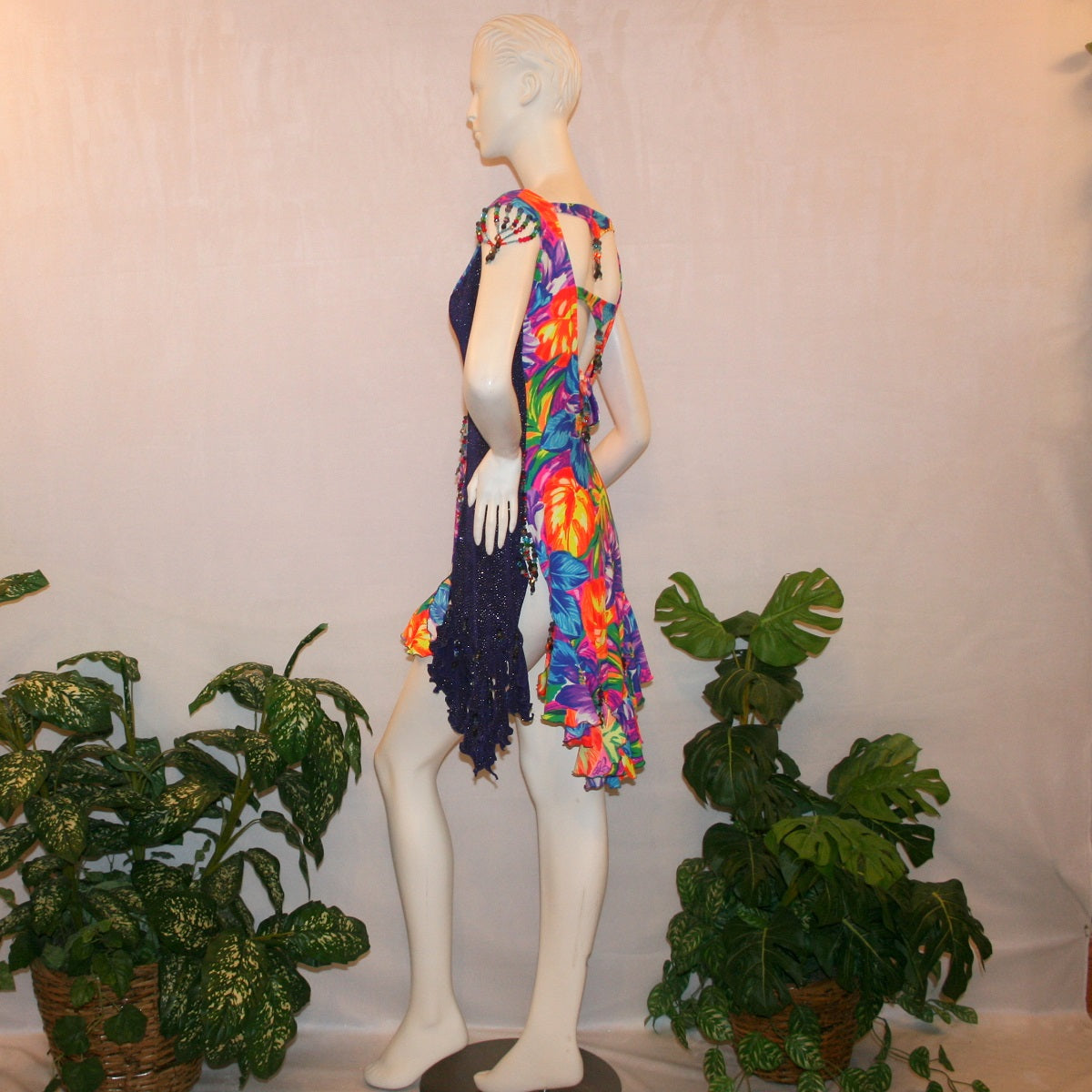 side view of Tropical print Latin-rhythm dress created in tropical print lycra with side color blocking in deep purple glitter slinky with lots or flounces, back detailing, embellishing with Swarovski hand beading.