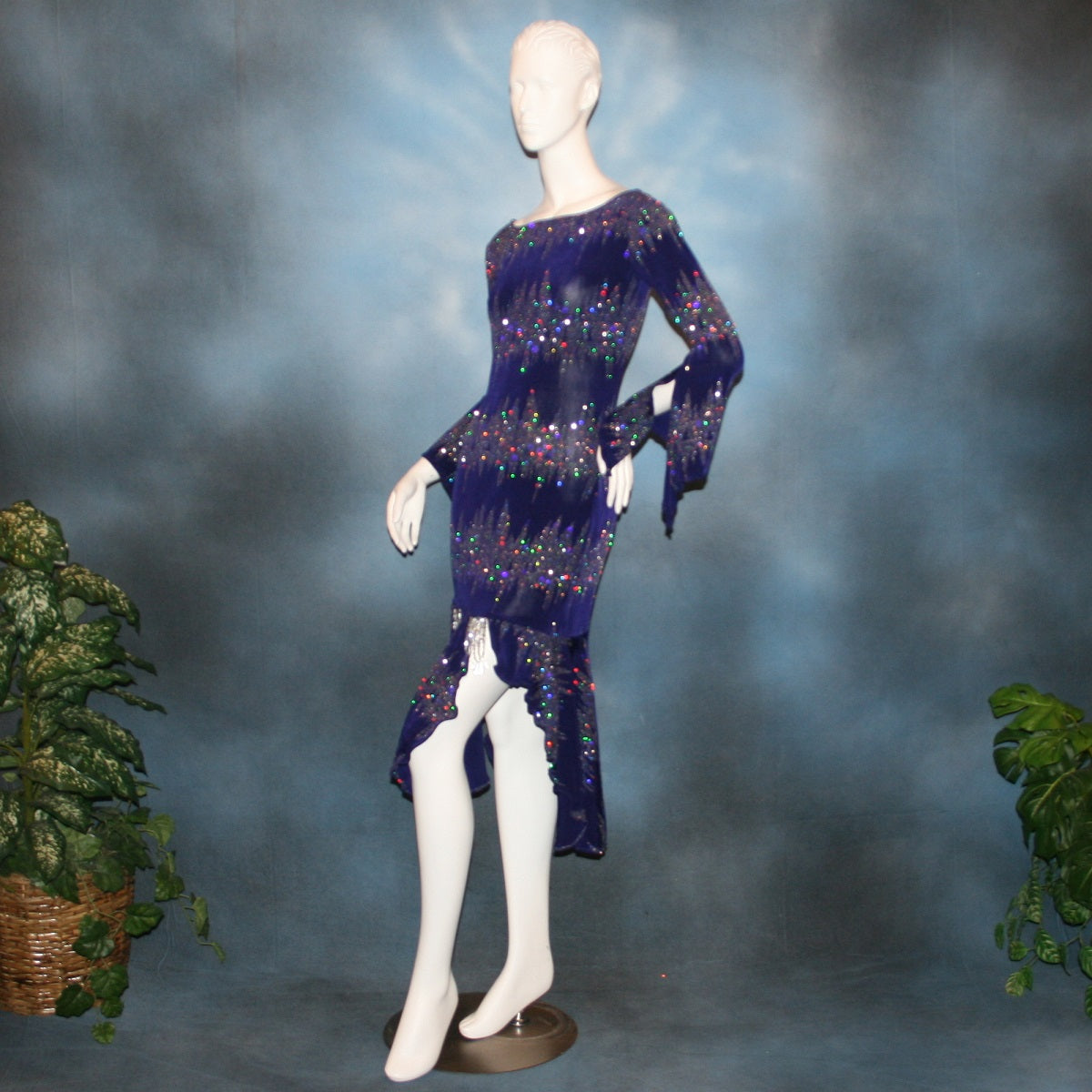 Deep royal purple Latin/rhythm/tango dress created in deep royal purple glitter slinky with an awesome electrifying glitter pattern features long flaired sleeves, lattice strap detailing up the low back & a touch of hand beading in skirting slits.