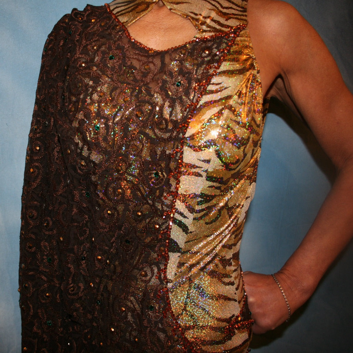 Crystal's Creations close up view of Gold tango dress or Latin/rhythm dress created in chocolate brown stretch lace that is lavishly embellished with gold & a touch of emerald green Swarovski rhinestones overlayed & draped over a golden hologram tiger print bodysuit size 3/4-9/10