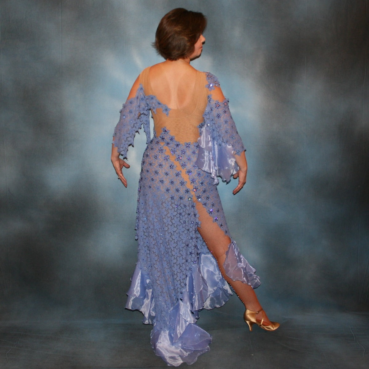 Crystal's Creations back view of Lavender Latin/rhythm dress created in periwinkle stretch lace on nude illusion base, with hand cut details, flounces of periwinkle organza, embellished with Swarovski rhinestone work of tanzanite, CAB, & tanzanite ab.