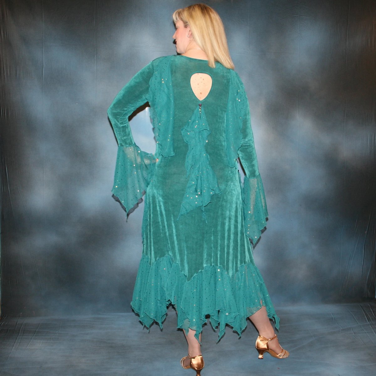 back view of Teal plus size ballroom dance dress was created in luxurious teal solid slinky with oodles of champagne sequined chiffon flounces & floats, embellished with a lovely touch of Swarovski hand beading on a blonde model