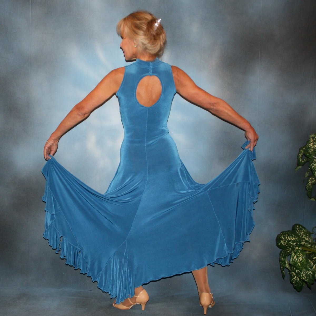 Crystal's Creations back view of  Blue ballroom dance dress created in luxurious medium blue solid slinky features flouncing at the bottom sides, includes gauntlets, plus can be worn with a bra… or a custom under body suit can be made to go with it, for an extra fee,plus is fabulous for beginner ballroom dancers. 