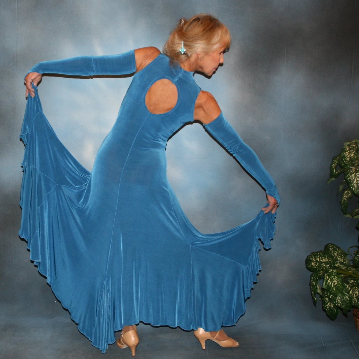 Crystal's Creations back view of Blue ballroom dance dress created in luxurious medium blue solid slinky features flouncing at the bottom sides, includes gauntlets, plus can be worn with a bra… or a custom under body suit can be made to go with it, for an extra fee,plus is fabulous for beginner ballroom dancers. 