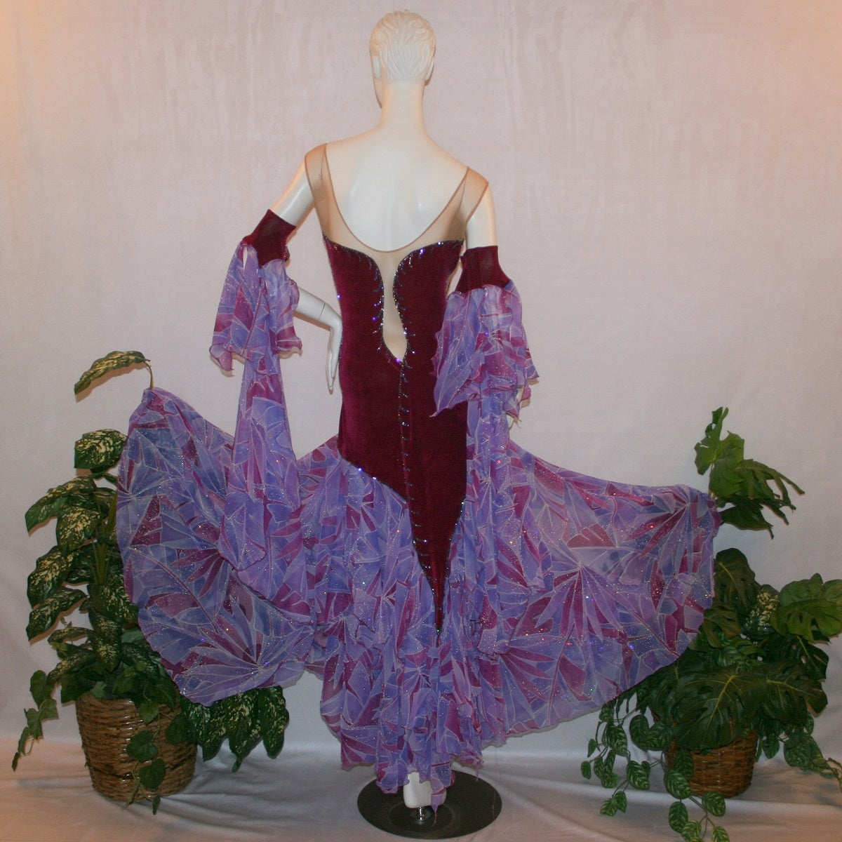 Crystal's Creations back view of Magenta converta ballroom dress created of magenta solid slinky on a nude illusion base with tropical chiffon print skirtings of magenta & orchids, is embellished with tanzanite & orchid rhinestone work.